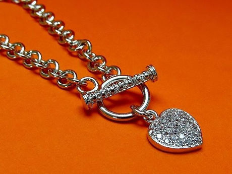 Afbeeldingen van “Pavé hart” armband in sterling zilver, rolo schakel ketting met hartvormig bedeltje en bar van kapittelslotje ingelegd met kubiek zirkonia