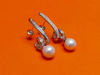 Picture of “Spiral and pearl” dangle earrings in sterling silver, a single cultured pearl dangling from a spiral inlaid with round cubic zirconia